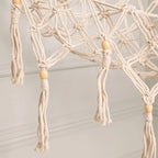 White macrame toy hammock holding plush toys